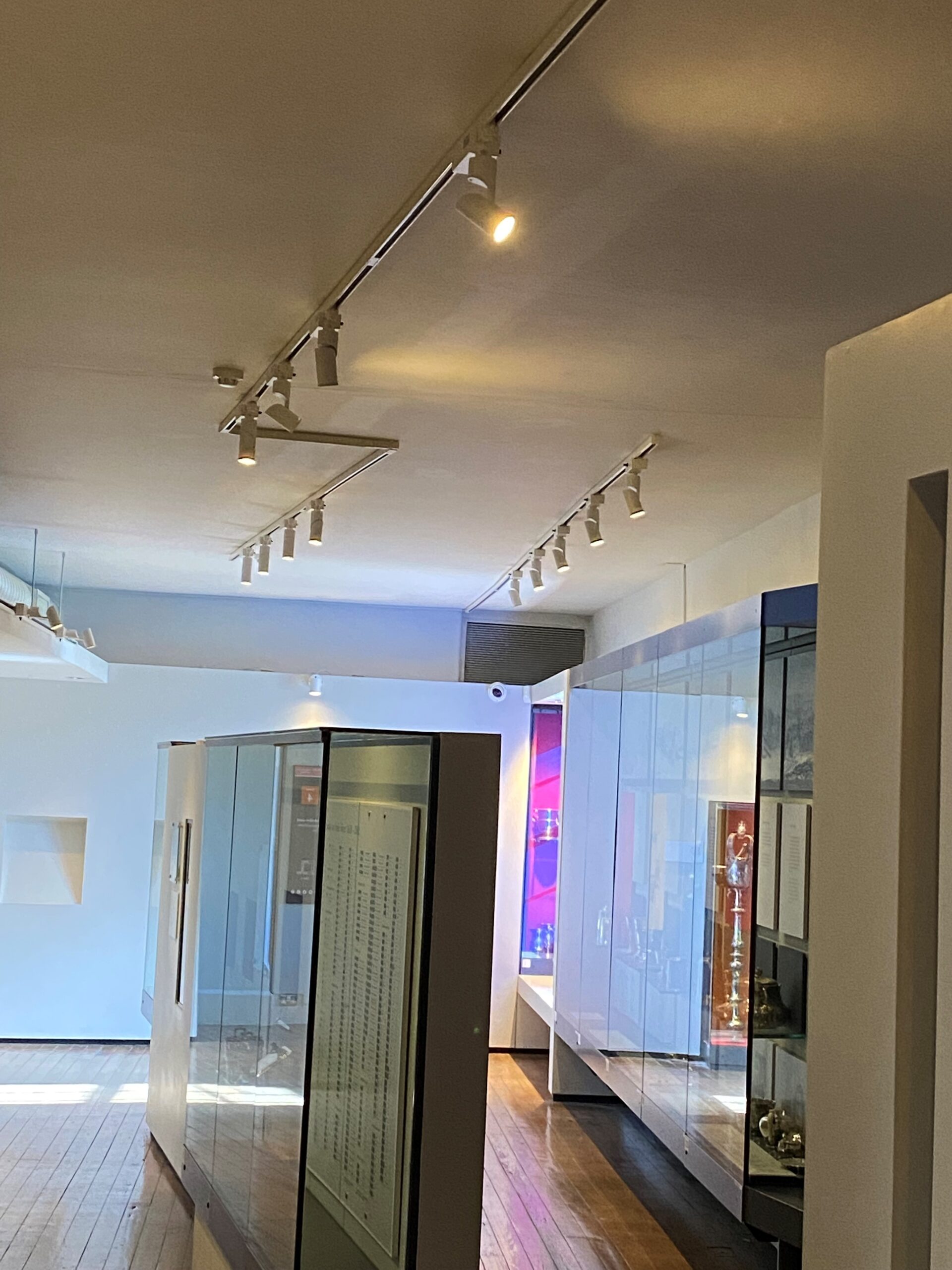 Close-up of ENCORE FLEX track rail with cylindrical track spotlights on a gallery ceiling