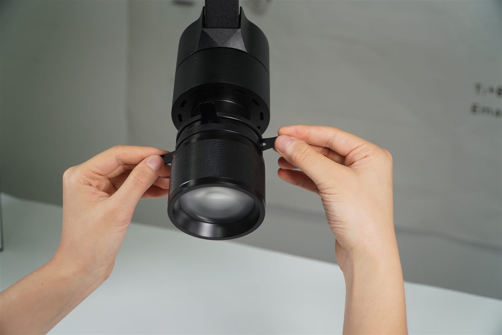 Hand adjusting zoomable beam angle on an ENCORE track light