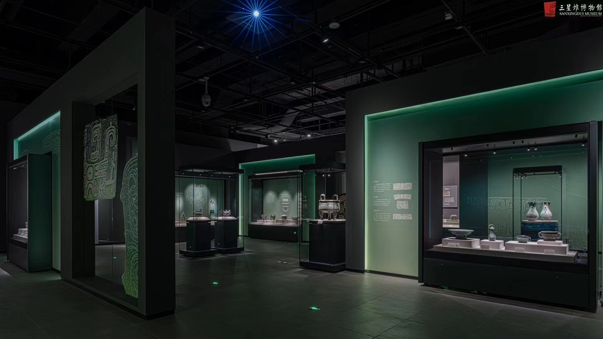 Sanxingdui bronze ritual vessels under warm track light and green LED cove lighting
