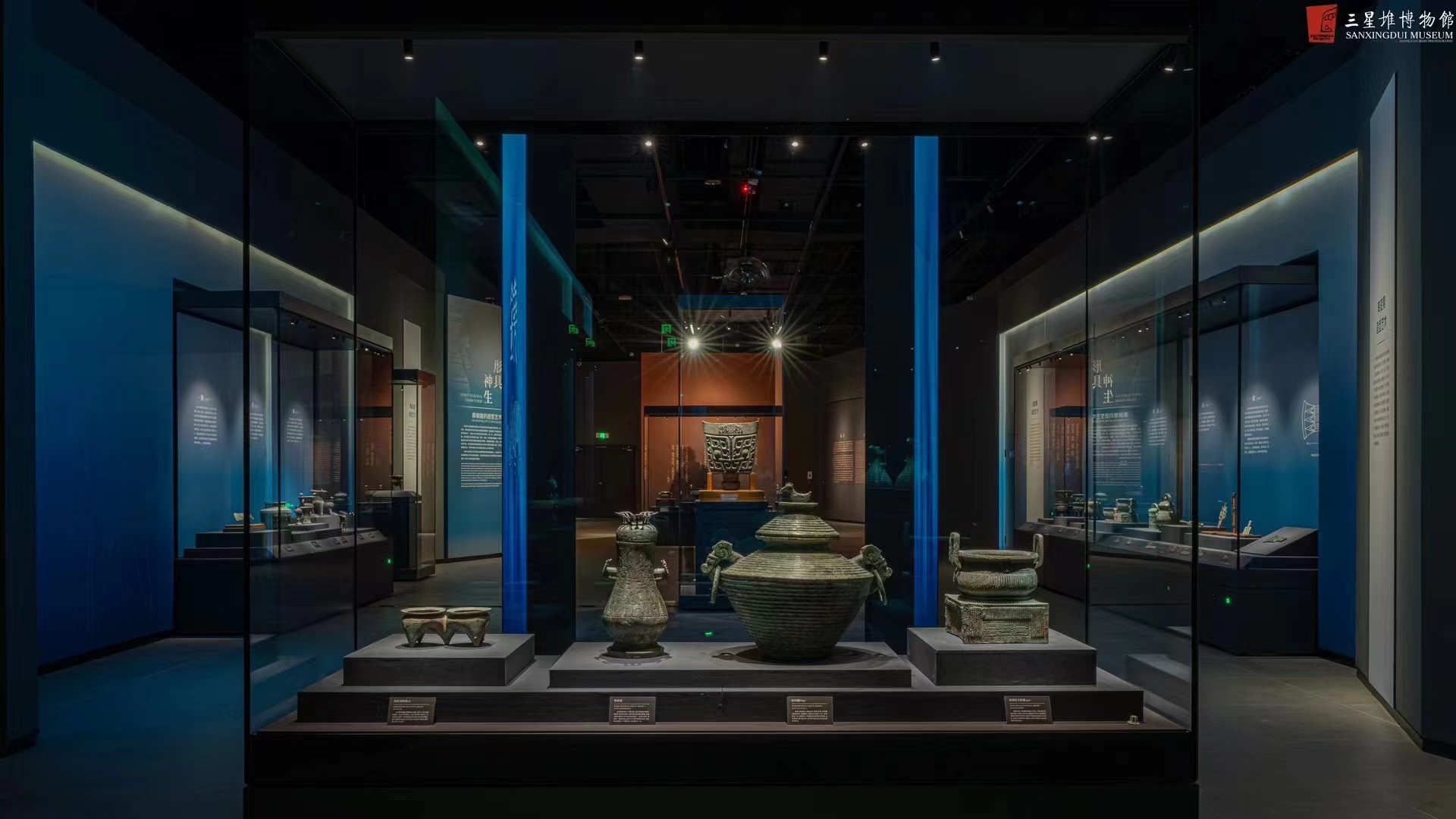 Hero bronze at Sanxingdui lit by narrow-beam track light against a blue light frame