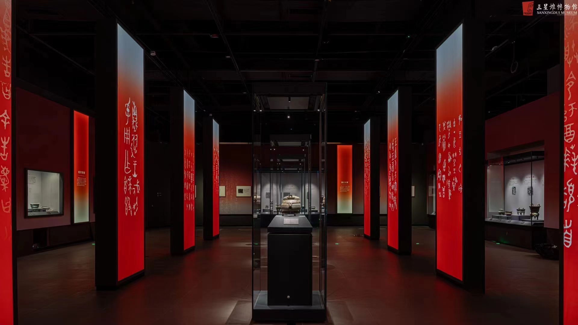 Sanxingdui red inscription corridor with edge-lit panels and track spots on bronze
