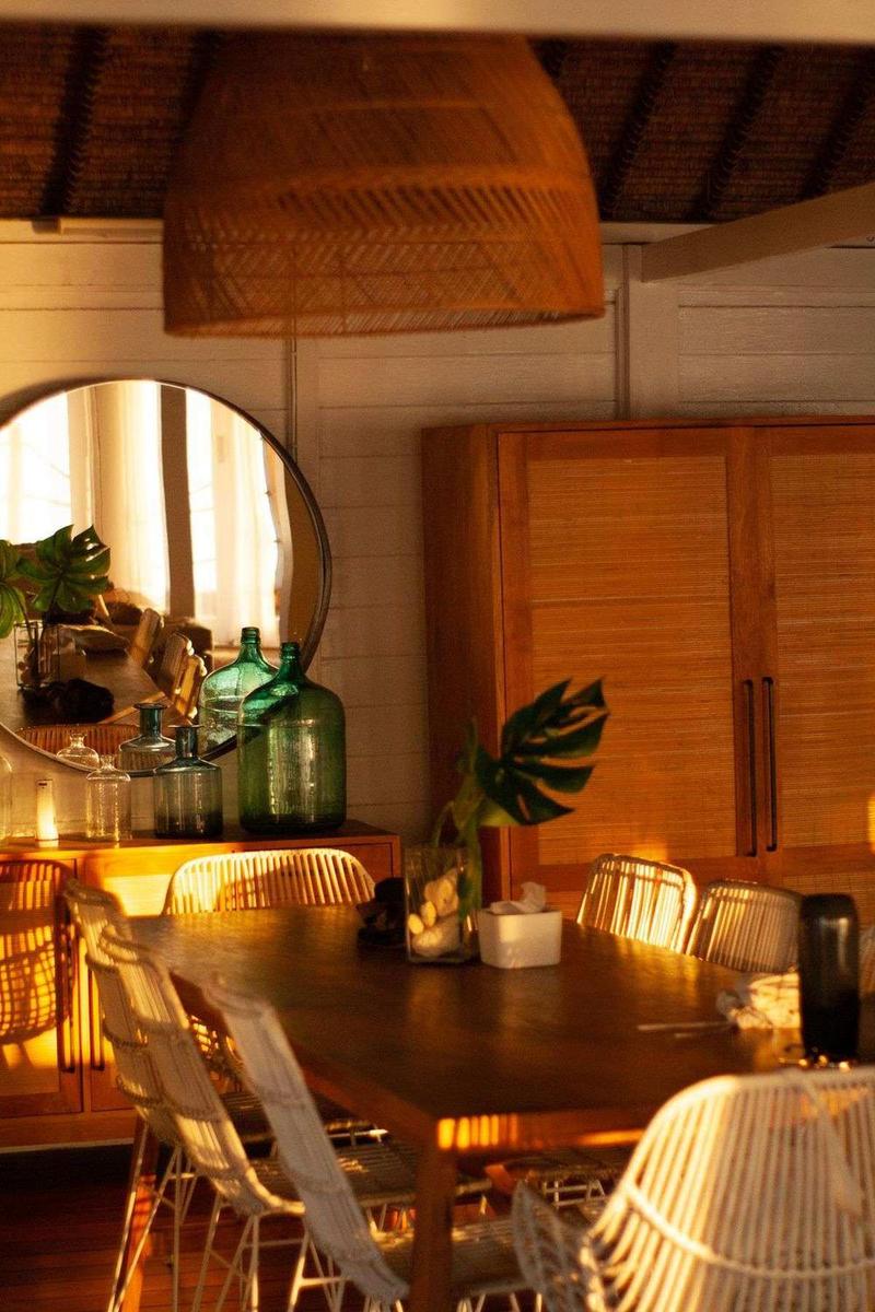 Warmly lit rustic dining room with wooden furniture and wicker chairs for cozy gatherings