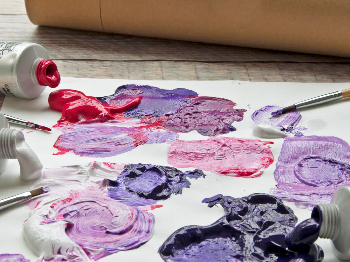 Mixed red purple and pink paint swatches on paper showing how R9 color rendering separates adjacent saturated hues