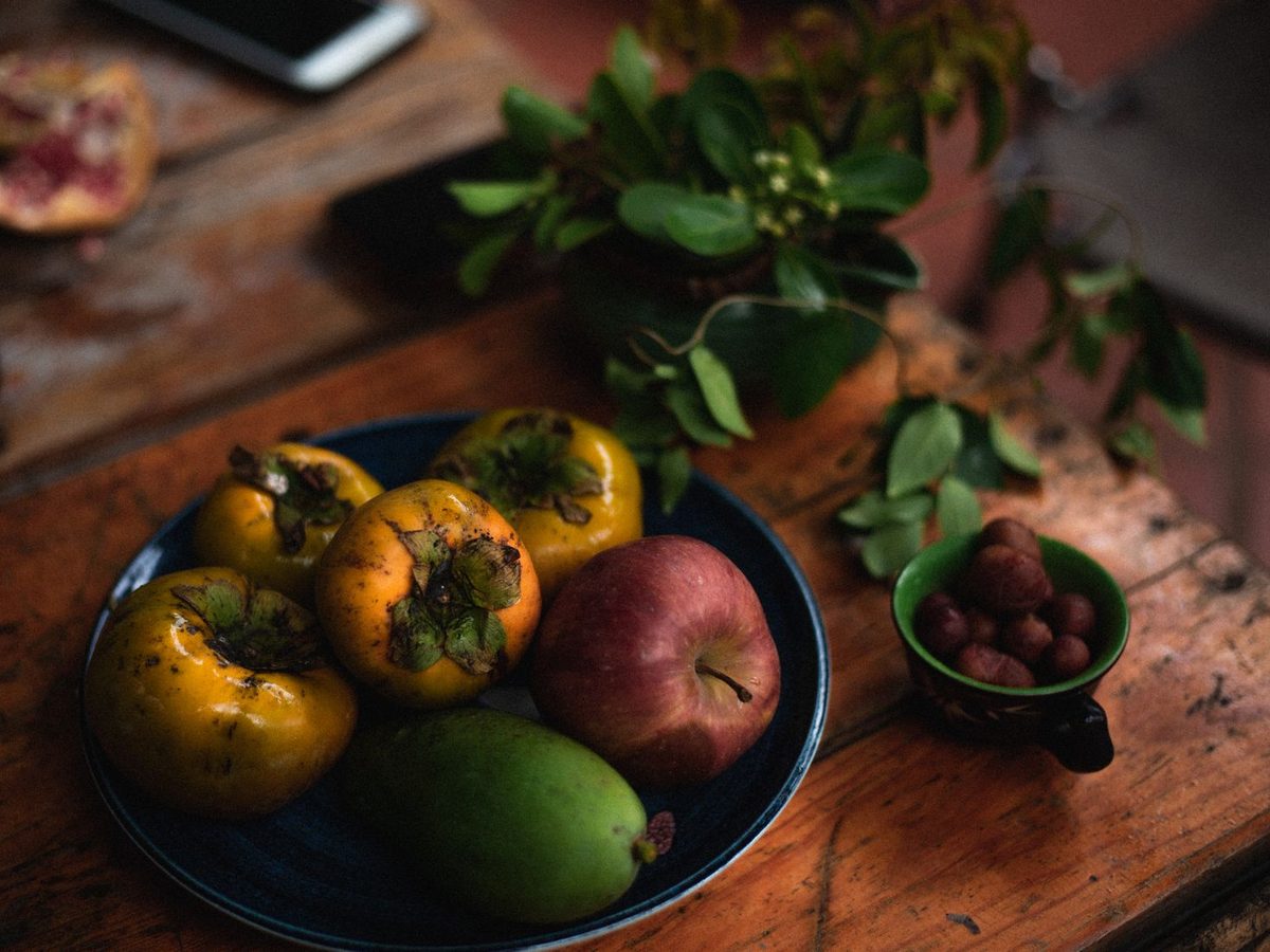 Fruit still life on a rustic wooden table under warm high-fidelity LED light showing TM-30 Rf and Rg colour accuracy