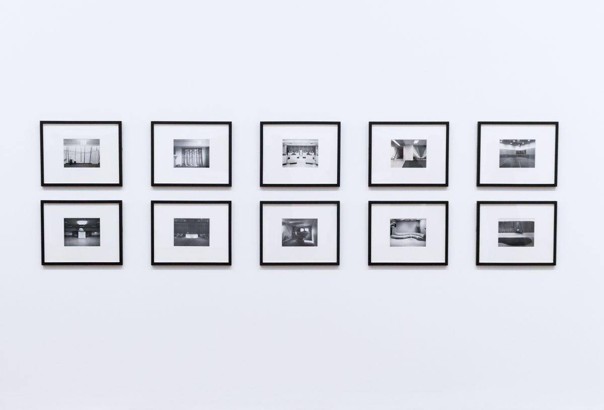 Elegant framed black and white photographs lit on a warm home wall for a gallery effect