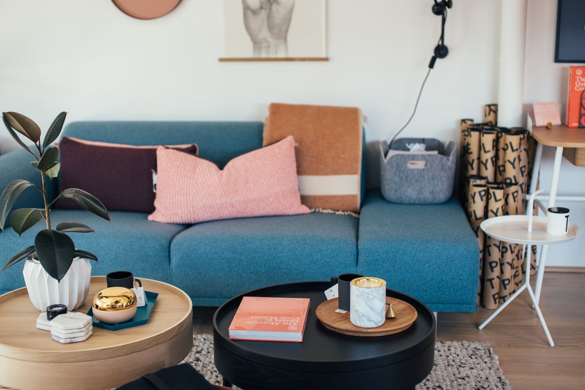 Cozy Scandinavian living room with soft sofa and framed art under warm gallery lighting