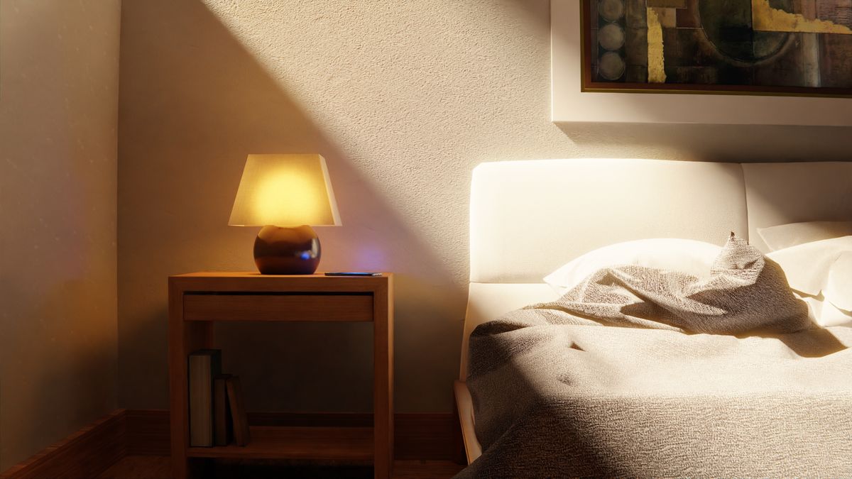 Warm bedroom with framed art above the bed softly lit by ambient gallery lighting