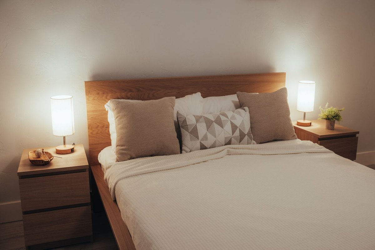 Bedroom bedside reading position with a shaded table lamp, the classic vertical-view glare case where the eye is level with the light source