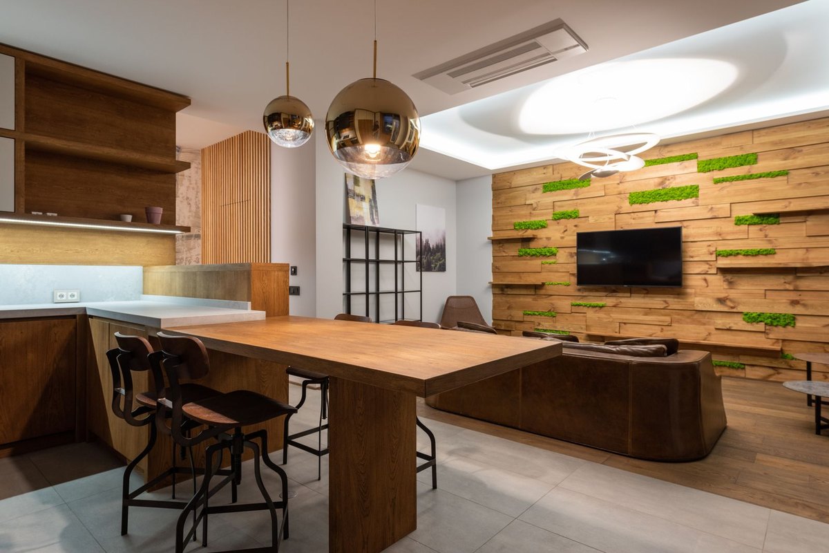 Open dining and living room with pendant lights over a table, showing how a lower mounting height and a large visible diffuser change perceived glare