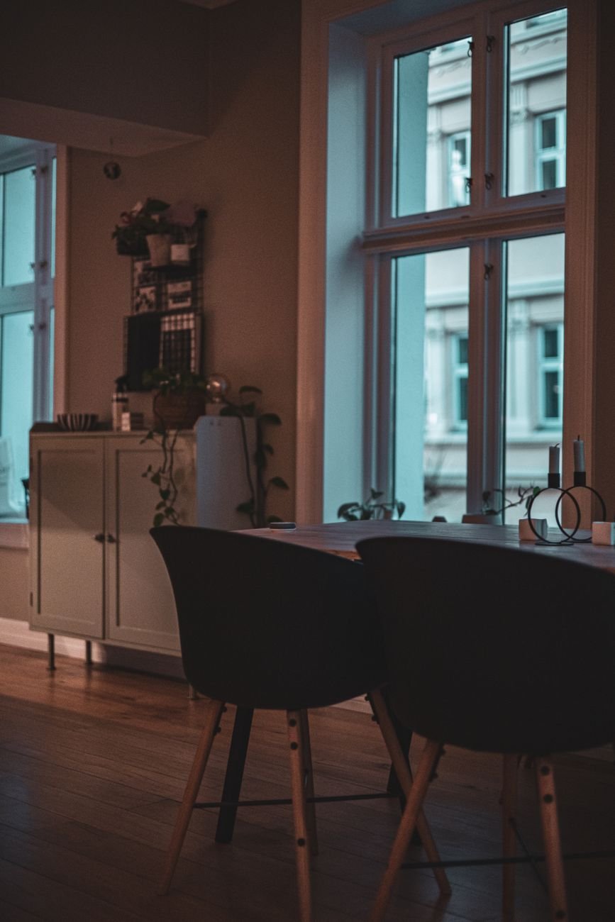 Warm dining area beside large windows with a view of Oslo architecture in a Nordic home