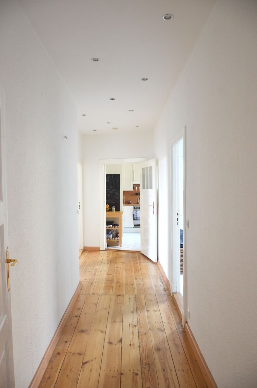 Spacious modern apartment corridor with white walls and wooden flooring in a Nordic building