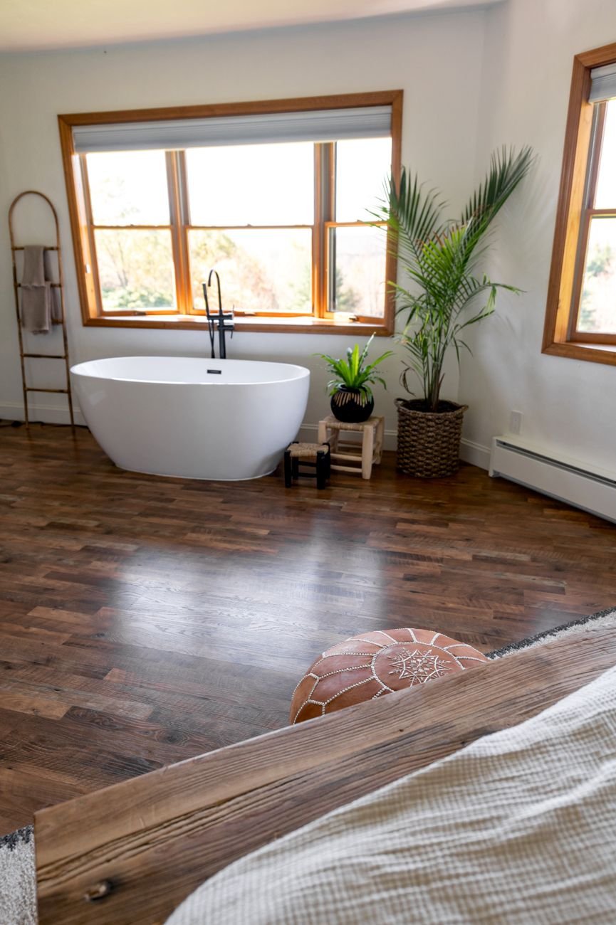 Elegant Scandinavian bathroom with freestanding bathtub and natural wooden accents at optimal lux levels