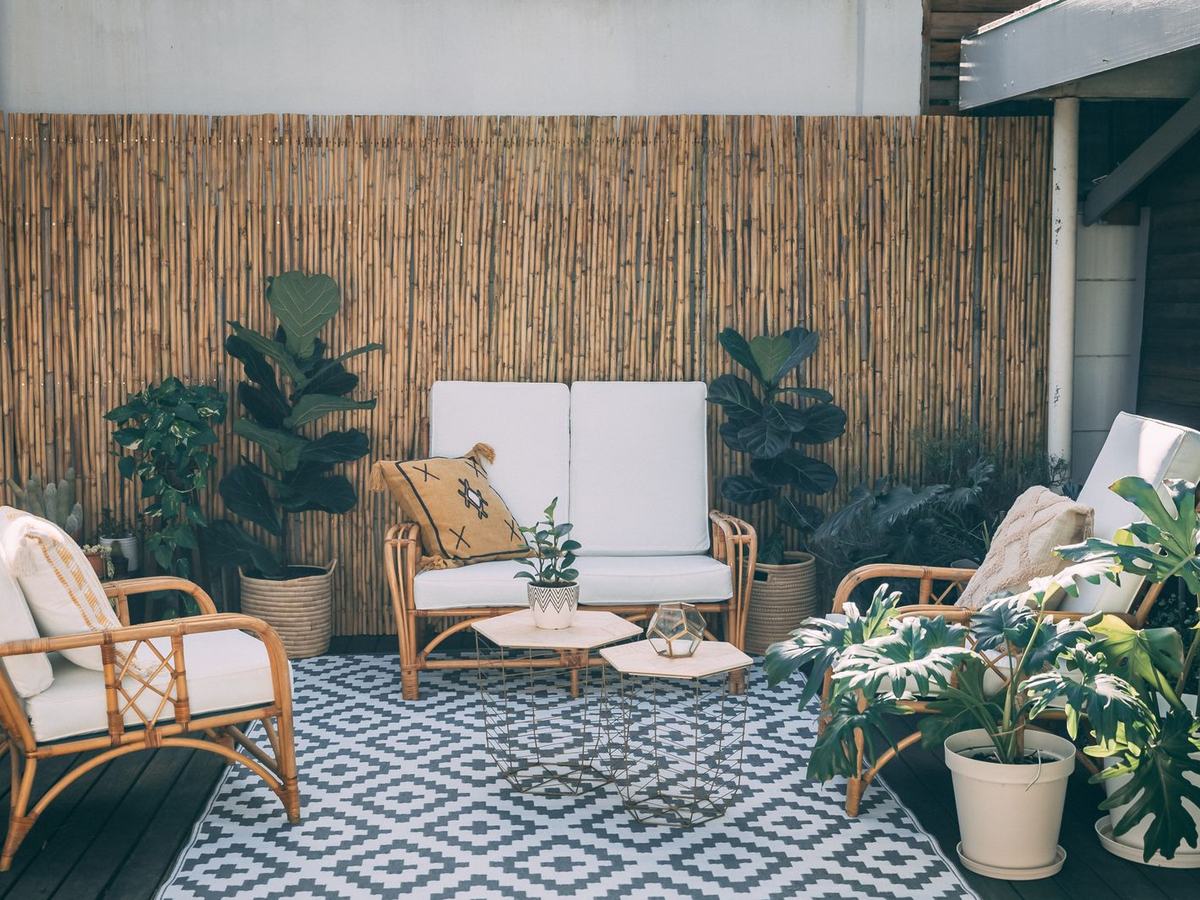 Boho rattan furniture and potted plants on a patio showing how TM-30 fidelity and gamut affect natural textures