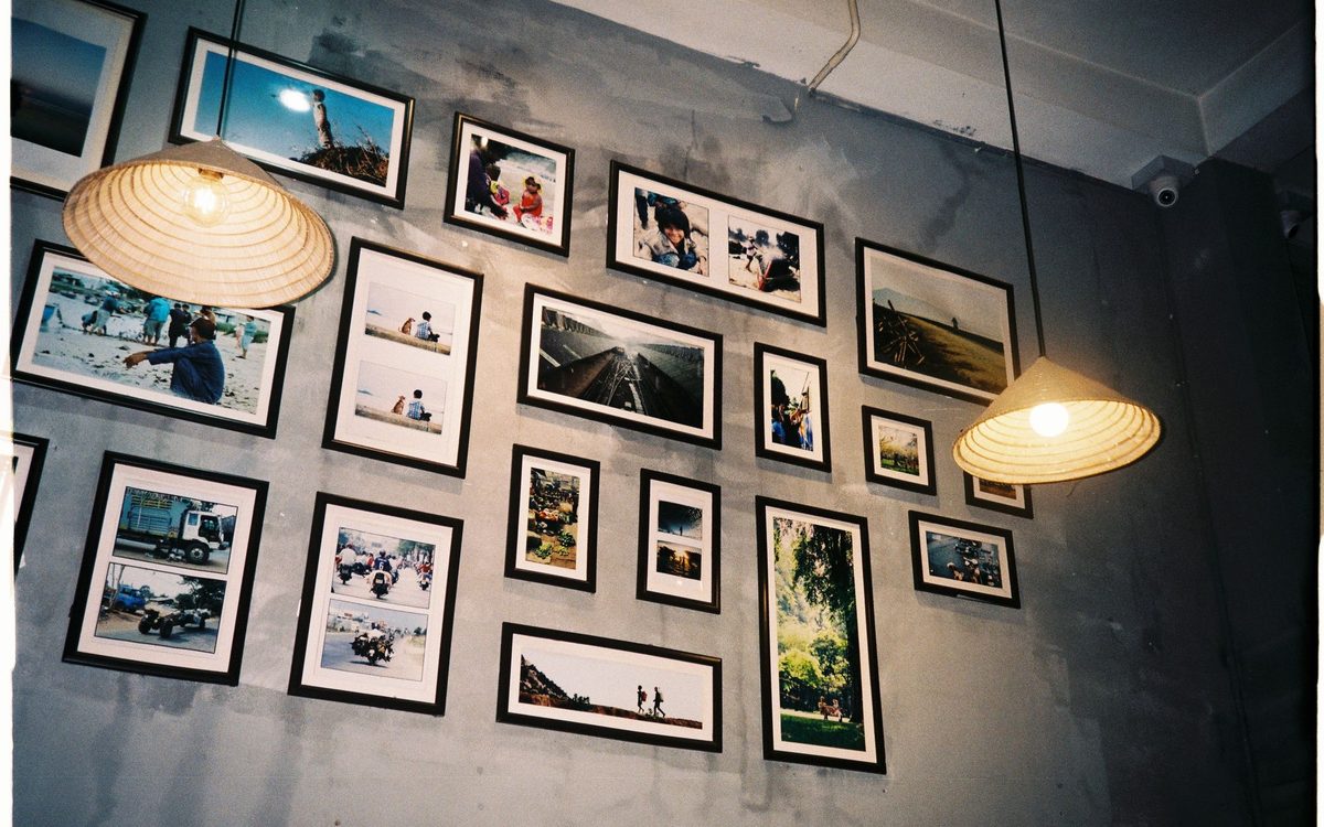 Gallery wall of framed photographs at home each illuminated by its own narrow beam track light