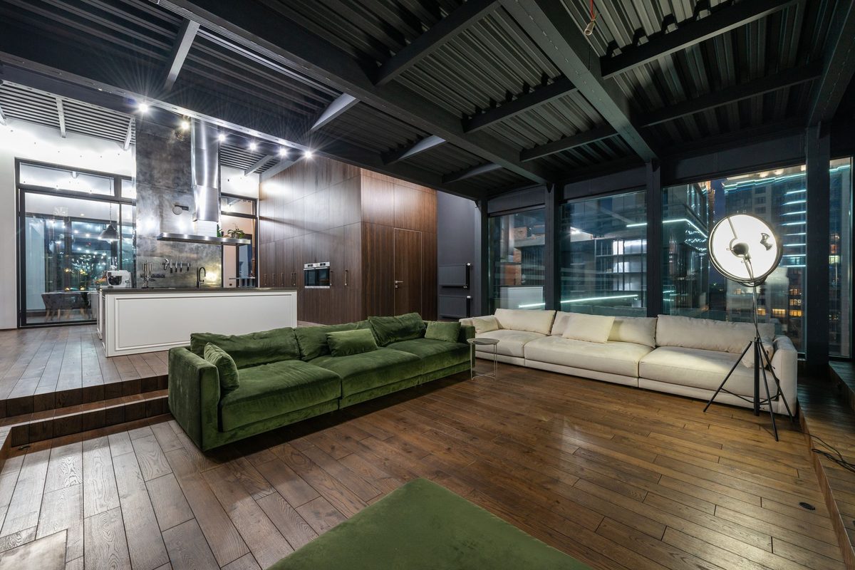Open plan loft living room with a high dark ceiling where track light spacing must scale with mounting height