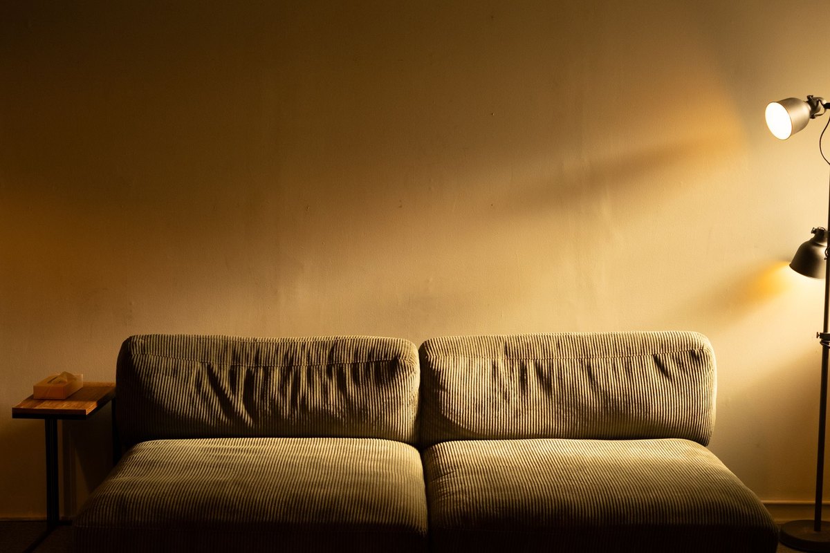Warm living room at dusk lit by track lights spaced roughly 2.7 ft apart for even ambient light