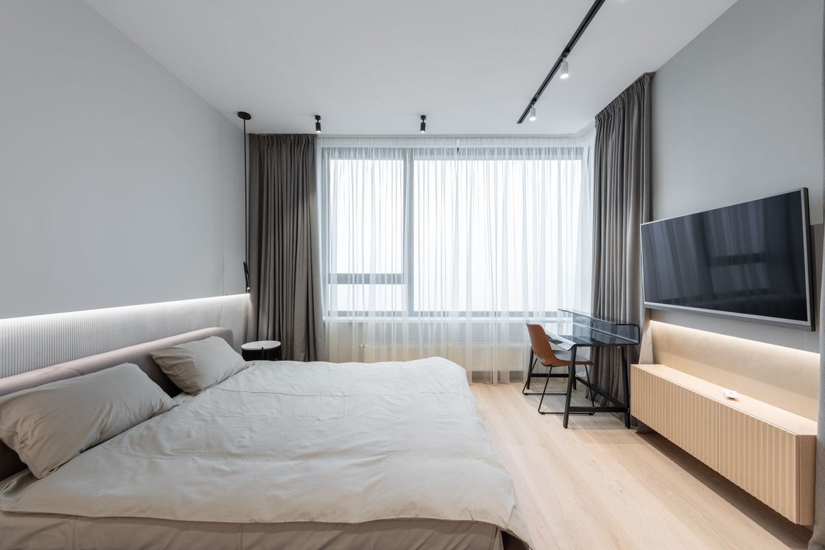 Minimal bedroom with a low ceiling where the track light pitch has to tighten to keep pools separate