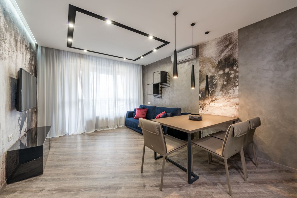 Wooden dining table under a flat ceiling showing the run that track light spacing is laid along